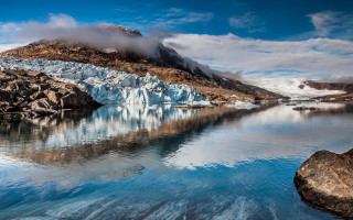 Glacier mountain water cloud sky - a mountain in the background and a body of water free wallpaper