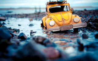 Yellow car water beach surfboard - tilt shift free wallpaper