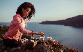 Woman sitting rock tea ocean - a rock free wallpaper
