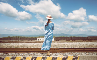 Woman blue dress hat train 2 - a train track in the background free wallpaper