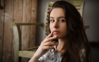 Woman sitting finger mouth portrait - a wooden wall free wallpaper for desktop