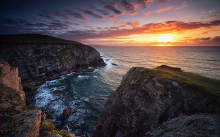 Sunset ocean rocky cliff boat - the water below free wallpaper