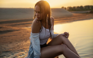 Beach woman sunset sitting blonde - the sun shining behind her free wallpaper