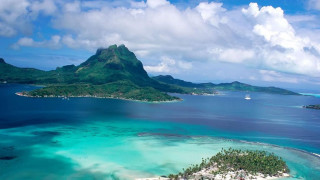 Tropical island sailboat mountain clouds - a sailboat free wallpaper