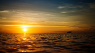 Boat ocean sunset mountains reflection - a boat in the distance free wallpaper