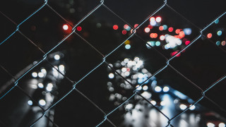 Blurry city street night chainlink - mesh wire free wallpaper