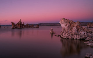 Purple sky rocks water mountains - a purple sky in the background free wallpaper for desktop