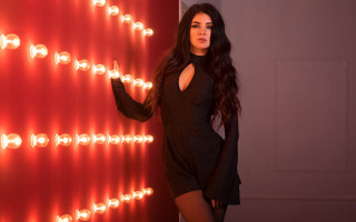 Woman black dress red wall 3 - a red wall behind her free wallpaper