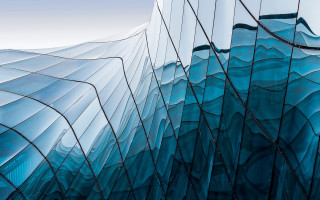 Curved glass facade blue sky - overhead in the background free wallpaper