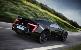 Black sports car green hillside 2 - a lush green hillside free wallpaper