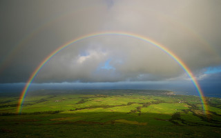 Rainbow green field cloudy sky - a dark cloud in the sky free wallpaper