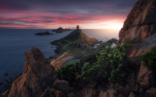 Lighthouse rocky cliff ocean sunset 9 - a red sky in the background free wallpaper