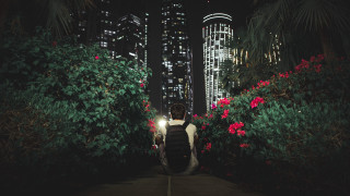 Night cityscape man walking backpack - a sidewalk free wallpaper
