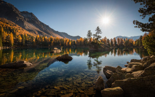 Lake mountains trees sun person - the shore free wallpaper