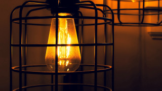 Lit bulb in caged fixture - caged free wallpaper