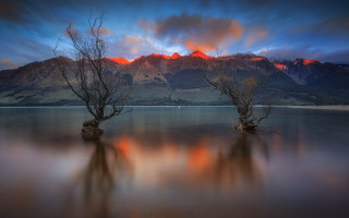 Trees water mountain sunset fire - the water near a mountain range free wallpaper