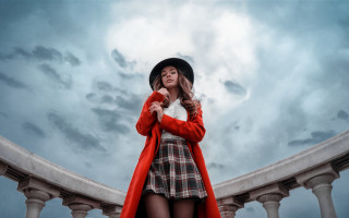 Woman red coat plaid dress - a cloudy sky behind her free wallpaper