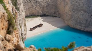 Boat beach cliff blue water - tilt shift free wallpaper