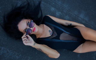 Tattooed woman sunglasses skyline fireworks - her arm behind her head free wallpaper