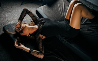 Woman black couch crossed legs - a black couch free wallpaper