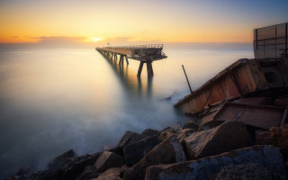 Pier rocky shore ocean sunset - a pier free wallpaper
