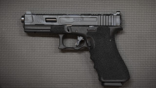 Black gun on table realistic - a stipple free wallpaper