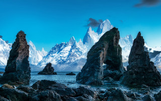 Beach rocks mountains sky water - a group of rocks free wallpaper