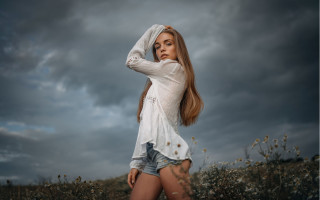 Woman long hair flower field 2 - a cloudy sky behind her free wallpaper