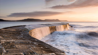 Wave crash stone wall sunset - a large wave free wallpaper