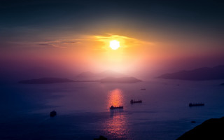 Sunset mountains water boats city - a sun setting free wallpaper