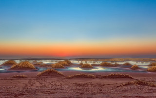Beach sand mounds sunset blue 2 - a blue sky and water free wallpaper
