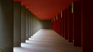 Red hallway symmetric doors columns - a long hallway free wallpaper