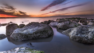 Sunset rocky beach water clouds 8 - a sunset over a rocky beach free wallpaper