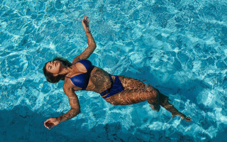 Blue bikini floating arabesque pool - her leg in the air free wallpaper