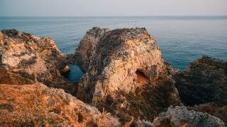 Rocky cliff hole ocean shore - a hole in the middle of it free wallpaper