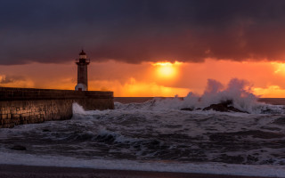 Lighthouse wave sunset stormy beach - a large wave free wallpaper