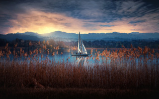 Sailboat lake mountains cityscape sunset - a sailboat free wallpaper
