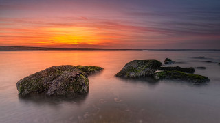 Sunset mountain shore mystical colors - the foreground and a body of water free wallpaper