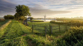 Grassy fence windmill river landscape - a grassy field free wallpaper