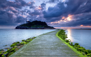 Wooden walkway island ocean cloudy - a sunbeam in the distance free wallpaper