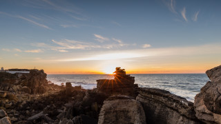 Rock sunset ocean tilt shift - the sun setting behind them free wallpaper for desktop