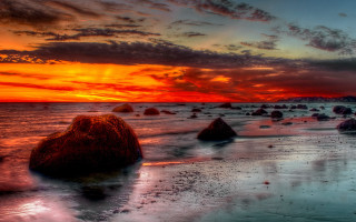 Sunset beach rocks clouds mountain 2 - a sunset over a beach free wallpaper