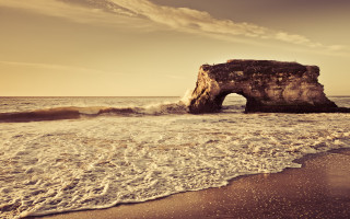 Rock formation beach waves person - a rock formation free wallpaper