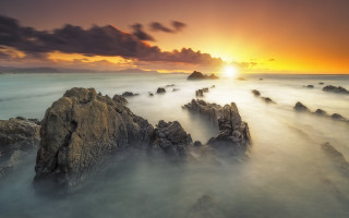 Sunset rocky beach clouds ocean 4 - a sunset over a rocky beach free wallpaper