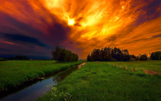 Sunset grassy field river trees - colorful cloud free wallpaper