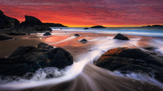 Sunset beach rocks water mountains - a sunset over a beach free wallpaper