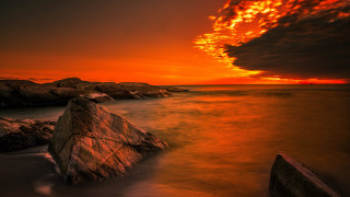 Sunset rocky beach large foreground - a red sky in the background free wallpaper