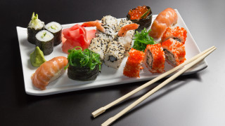 Sushi plate chopsticks black background - a black table free wallpaper