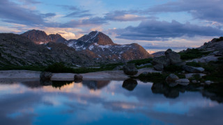 Mountain lake rocks snowy horizon - a few snow free wallpaper