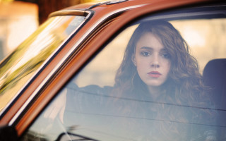 Woman car serious portrait blurry 2 - her face and shoulder free wallpaper